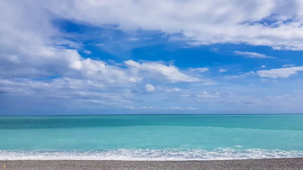 A view of a turquoise Mediterranean Sea and bright blue sky with fluffy clouds in Nice, France